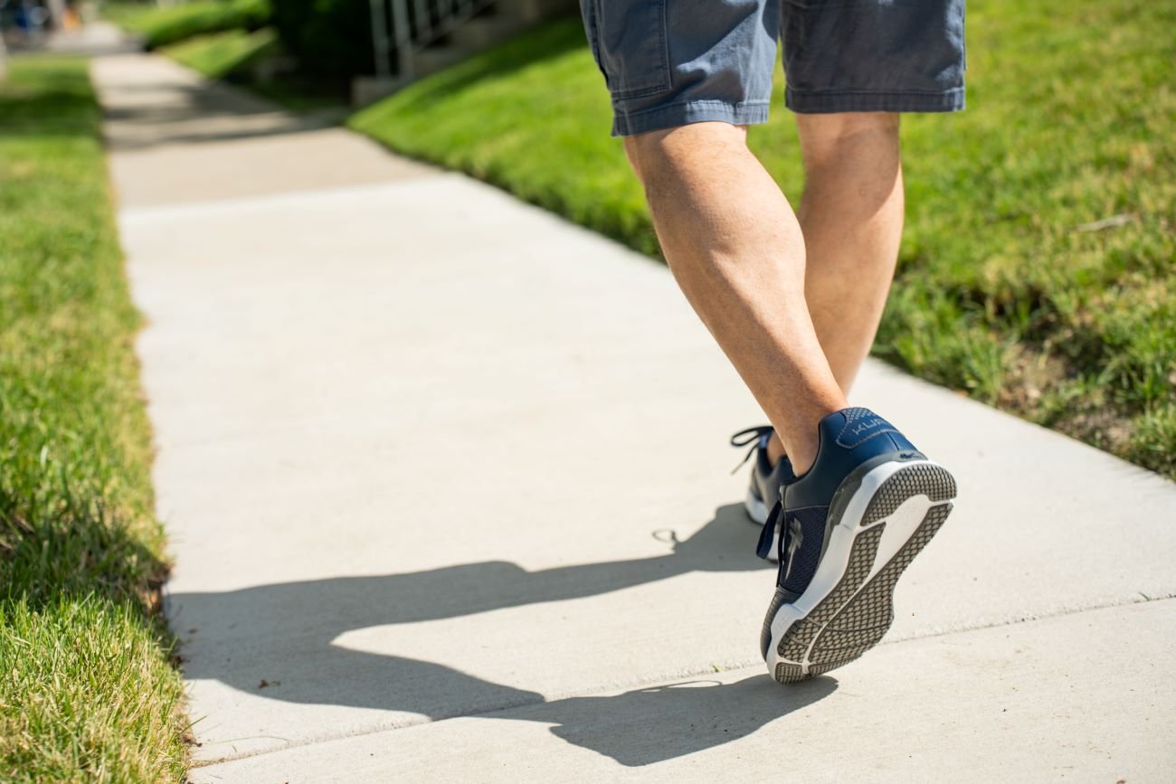 Man wearing walking shoes walking on a summer day.