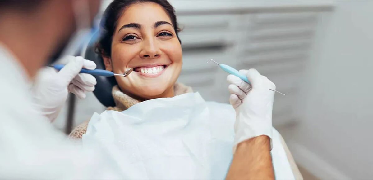 woman getting teeth cleaned at dentist