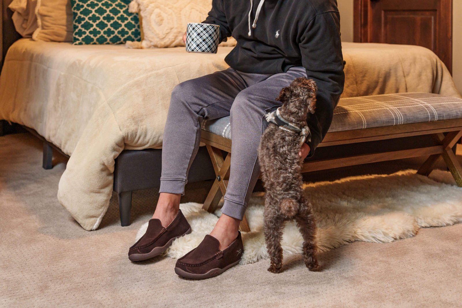 Man wearing KURU LOFT indoor shoes petting his dog.