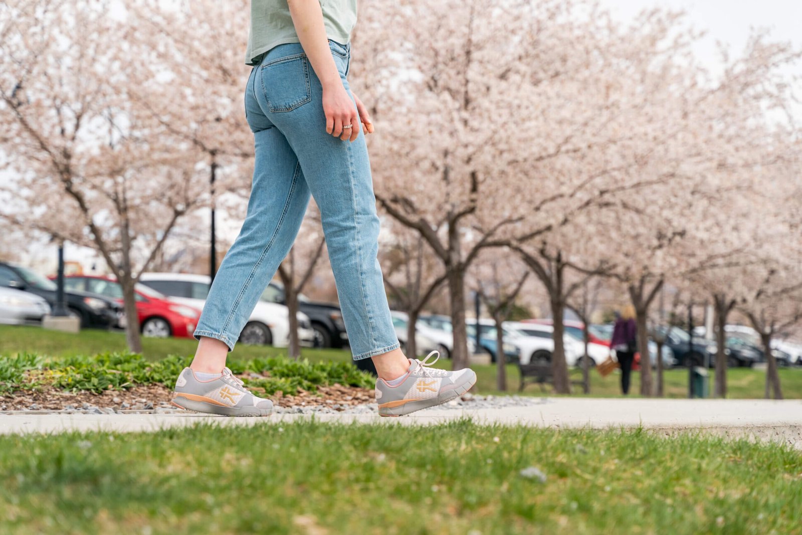 Woman walking through a park wearing KURU QUANTUM shoes for walking.